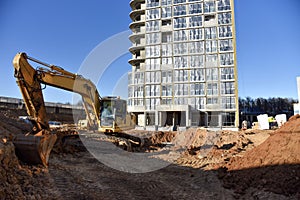 Excavator on earthworks for laying heating pipes and stormwater in trench. Installing concrete wells, Ñhambers, manholes near new