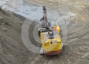 Excavator with electric shovel loading the rocks in mining truck at quarry. Haul truck transports minerals in the open pit. Open-