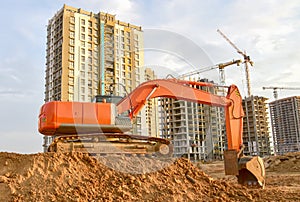 Excavator during excavation aond road construction works at construction site on sunset background. Backhoe on foundation work in