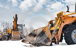 Excavator, grader in winter at the construction site. Construction equipment. Construction