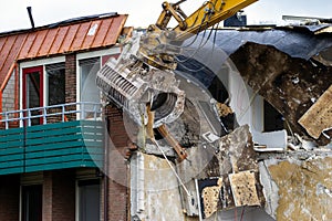 Excavator gripper demolishing an obsolete building
