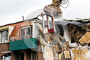 Excavator gripper demolishing an obsolete building