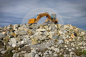 Excavator on heap of stones