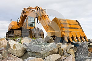 Excavator on heap of stones