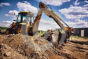 Excavator at house construction site - digging foundations for modern house