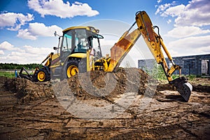 Excavator at house construction site - digging foundations for modern house