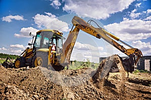 Excavator at house construction site - digging foundations for modern house