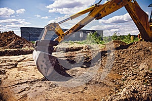 Excavator at house construction site - digging foundations for modern house
