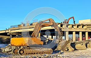 Excavator hydraulic crushes concrete slabs.