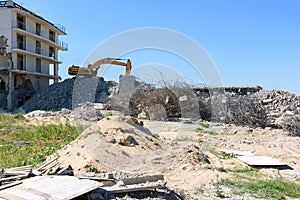 Excavator with hydraulic hammer dismantling a building
