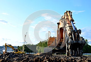 Excavator with hydraulic shears breaks asphalt on a construction site. Hydraulic shear crusher pulverizer for excavator.