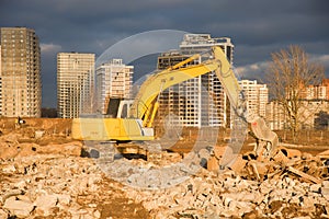 Excavator with hydraulic shears  on a construction site cuts and crumbles old concrete and asphalt. Hydraulic breaker grinder.