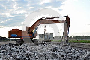 Excavator with hydraulic shears for cutting and crumbles demolition concrete and asphalt at construction site. Hydraulic breaker.