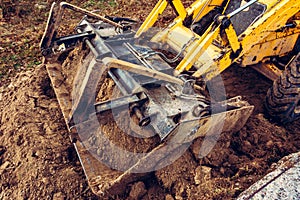 Excavator with a large iron bucket on a construction site during road works, Backhoe dig the ground for the foundation