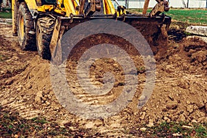 Excavator with a large iron bucket on a construction site during road works, Backhoe dig the ground for the foundation