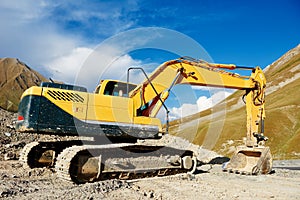 Excavator loader machine at mountain road construction site