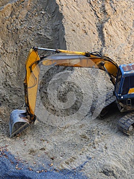 Excavator Loader with rised backhoe standing in sand
