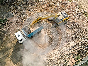 excavator loading debris of a destroyed building in truck. aerial view of demolition site