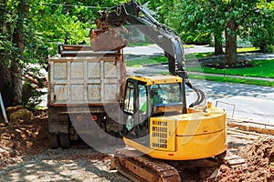excavator is loading dirt on truck for construction