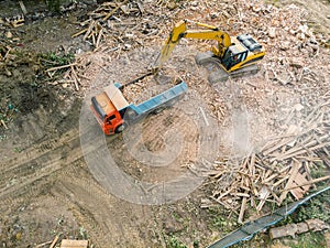 Excavator loading a dump truck after demolishing houses. aerial