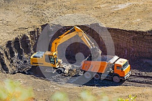 Excavator loading a dump truck in a quarry