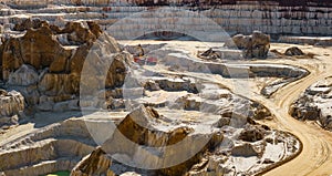 Excavator loading dump truck with raw kaolin in kaolin open pit mine