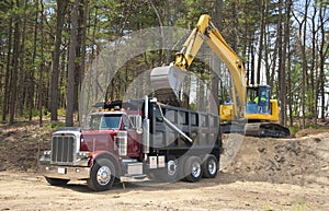 Excavator loading dumper truck photo