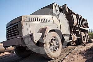 Excavator loading dumper truck with sand at a sand quarry