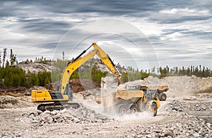 Excavator loading dumpers with blasted stone
