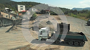 Excavator loading gravel in dump truck.