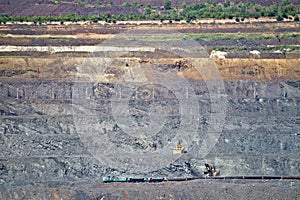 Excavator loading iron ore into goods wagon on the iron ore opencast mine