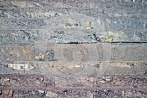 Excavator loading iron ore into goods wagon on the iron ore opencast mine