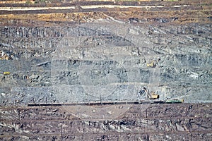 Excavator loading iron ore into goods wagon on the iron ore opencast mine