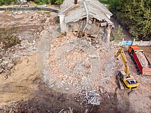 Excavator loading out rubbish and debris into dump truck. demolition site top view