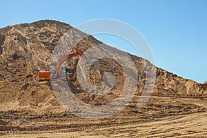 Excavator loading sand at big construction site