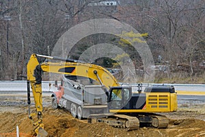 excavator loading sand into a dump truck