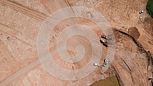 Excavator loading sand into large truck, aerial view