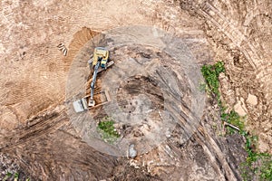 Excavator is loading soil into a dump truck. earthworks on construction site. aerial view from above