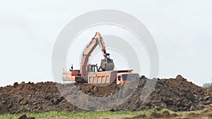 Excavator loading a transportation truck on construction site.