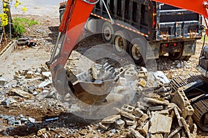 Excavator loads construction waste into of material for disposal from construction
