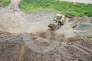 excavator loads crushed stone into dump truck