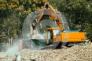 The excavator loads the dump truck with gravel.