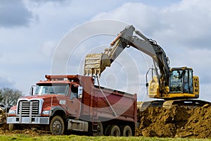 excavator loads earth onto big dump truck