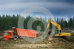 Excavator loads excess soil into dump trucks