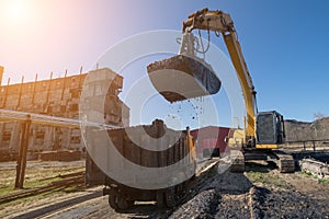 Excavator loads mineral oils in truck