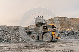 Excavator loads ore into a dump truck.