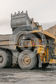 Excavator loads ore into a dump truck.