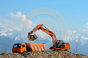 Excavator loads rubble into a truck