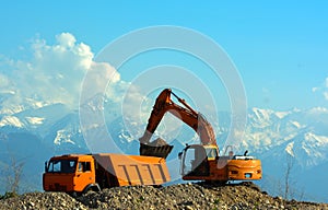 Excavator loads rubble into a truck