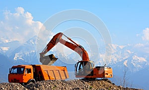 Excavator loads rubble into a truck